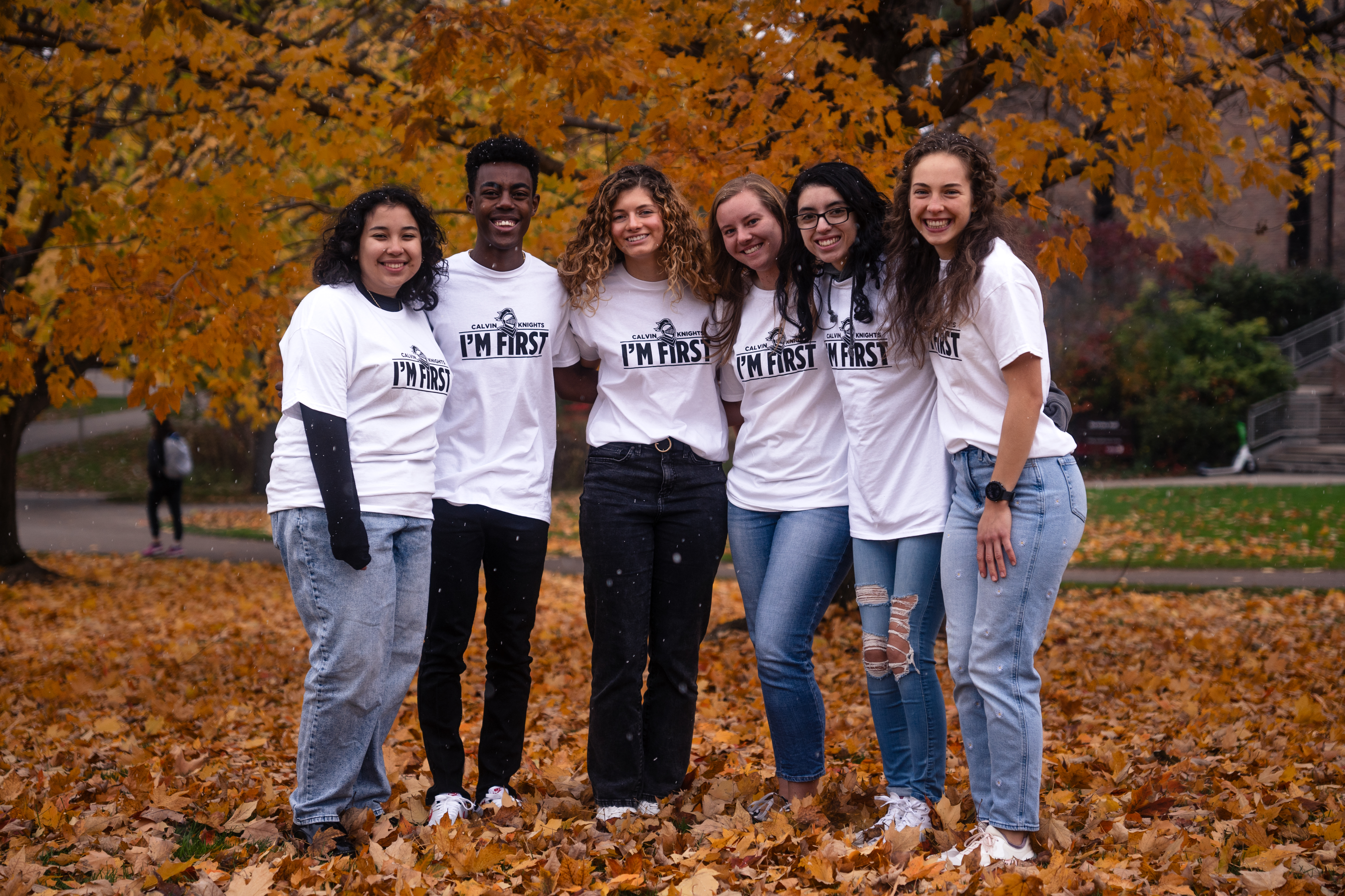 Calvin University students posing in the fall leaves in campus