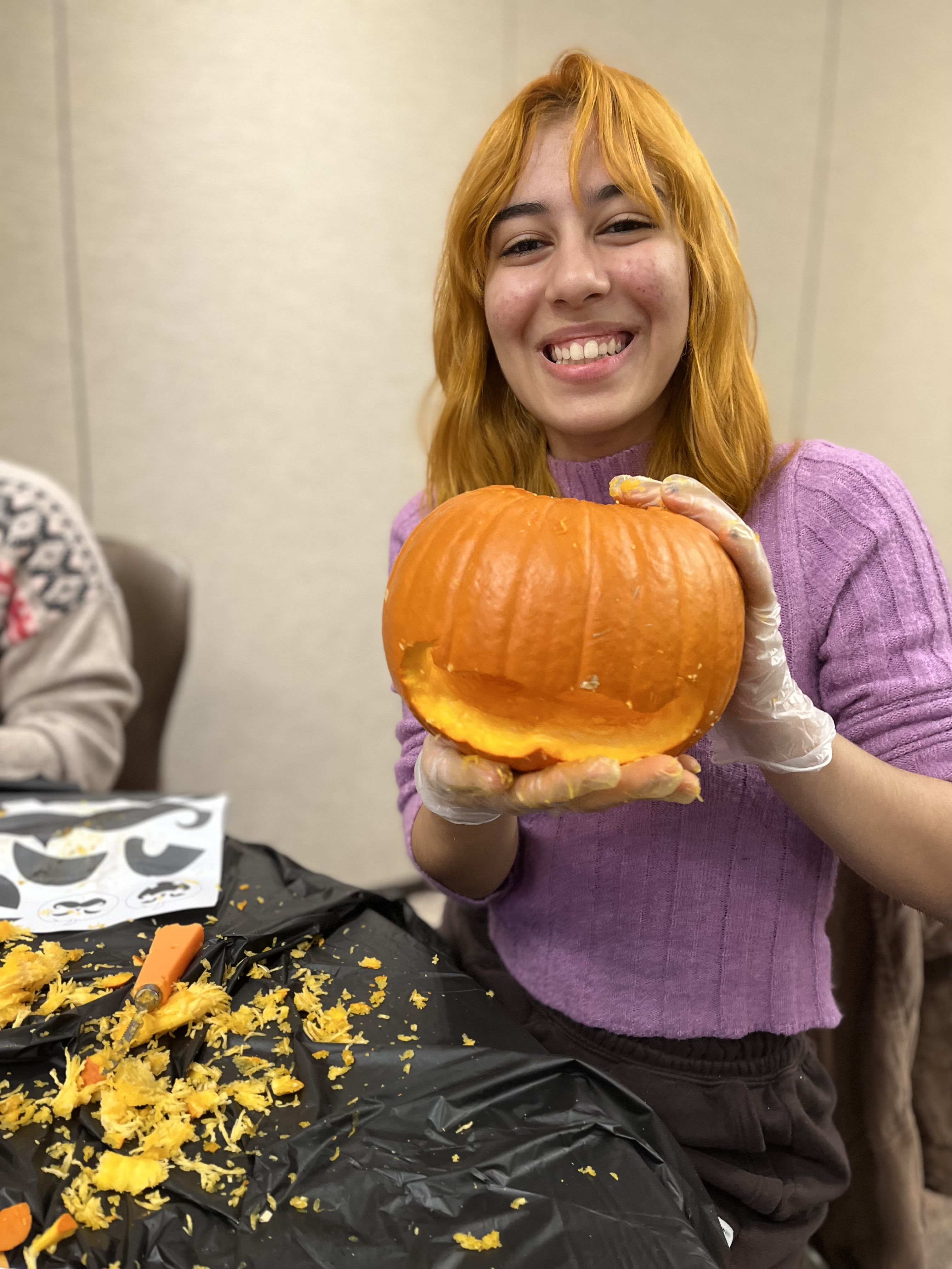 Student holding pumpkin
