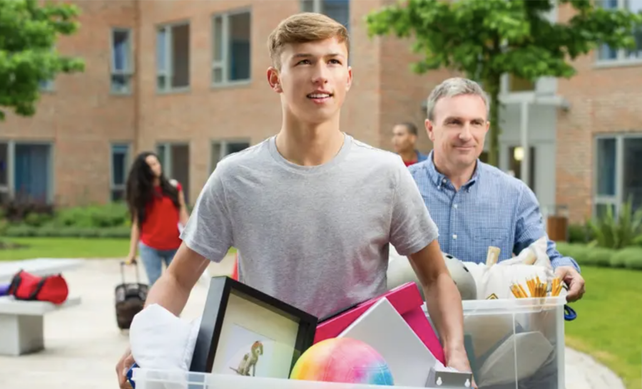 Male student moving in to residence hall with parent