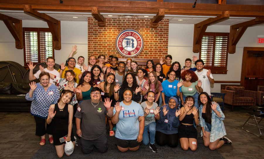University of Richmond student group posing below institution seal inside