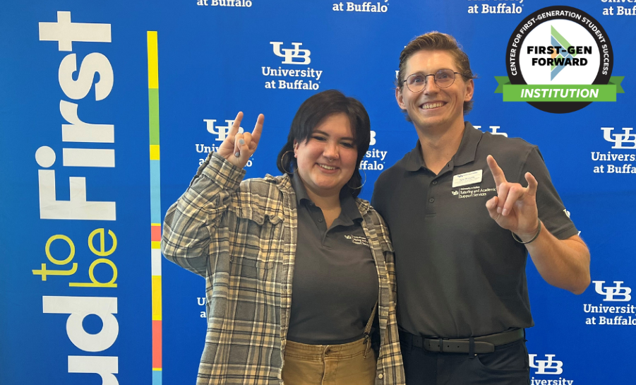Two staff members in front of University at Buffalo step and repeat